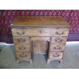 A good quality Georgian mahogany desk with a slide above seven drawers and a central cupboard raised