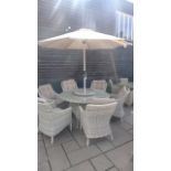 A Bramblecrest Ascot 140cm round table with Lazy Susan and parasol and six armchairs and cushions,