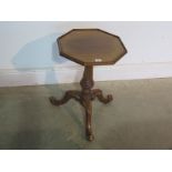 An octagonal top side table with ornately carved pedestal support and feet, slight wear to feet