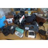 A collection of vintage cameras and attachments