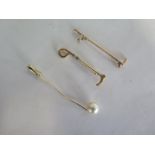 A 14ct gold riding crop pin brooch, approx 2.6 grams, and two other pins, one broken