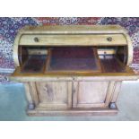 A 19th century mahogany cylinder top writing desk with two cupboard doors, with a fitted interior,