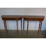 A pair of walnut D shaped side tables each with a single drawer on turned reeded legs, 77cm tall x