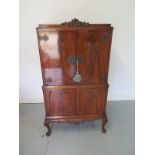 A flamed mahogany cocktail cabinet with a maple interior raised on cabriole legs - 160cm H x 82cm