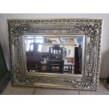 A contemporary bevelled edged over mantle mirror with ornate silvered frame, approx 120cm x 95cm -