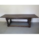 An antique oak refectory table with a carved frieze and turned legs, 244cm long x 74cm wide, with