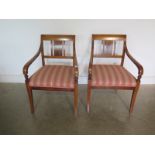 A pair of Swedish Karl Johan style mahogany armchairs with upholstered seats and tapered legs,