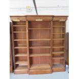 An oak breakfront bookcase with adjustable shelves and three brass lamps which would need re wiring,