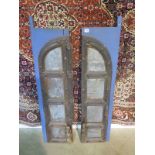A pair of carved Eastern doors with metal panels and figural handles, 116cm tall x 58cm wide total