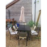 An aluminium rectangular dining table with six armchairs, cushions and a parasol with base by Lazy