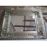 A contemporary bevelled edged over mantle mirror with ornate silvered frame, approx 120cm x 95cm -