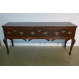 An 18th century oak three drawer dresser base on shaped front legs with old restorations, good