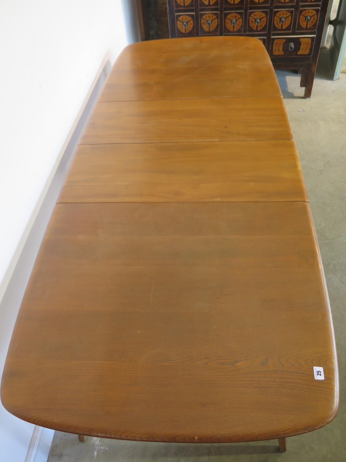 An Ercol blonde elm and beech extending table with a folding two section leaf raised on five - Image 2 of 2