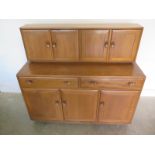 An Ercol blonde elm and beech dresser with four cupboard doors over two doors and three cupboard