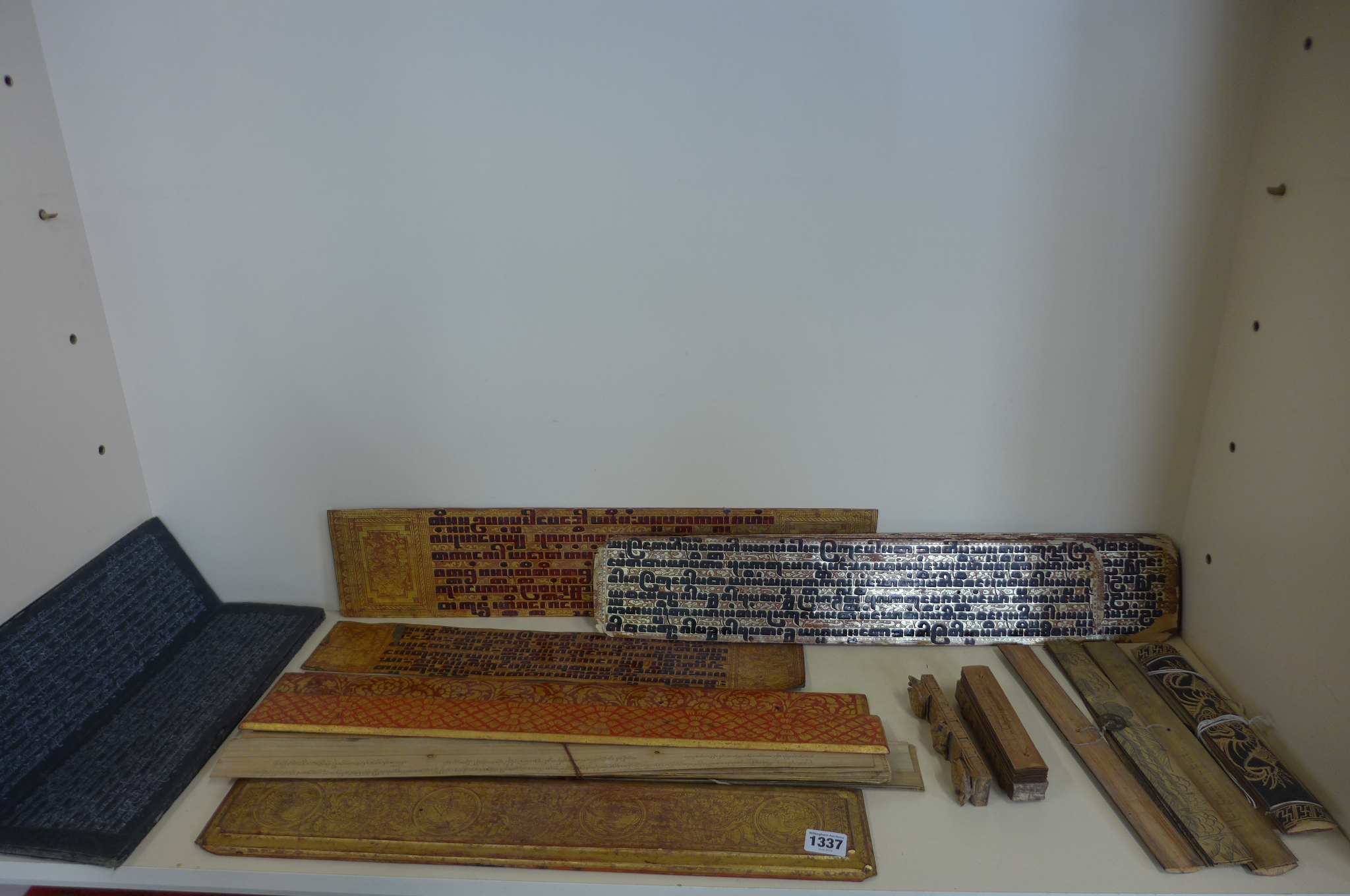 A collection of Tibetan prayer scripts, including a carved block - 15cm long