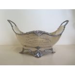 A silver twin handled bowl, raised upon scroll feet, London 1922, with presentation inscription, The