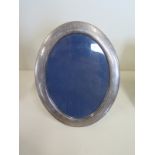 A large silver oval photo frame, approx 22.5cm oval