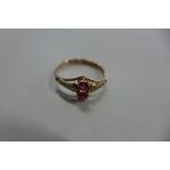 A yellow metal dress ring with pearls, ruby coloured stones, size K, approx 0.8 grams, usage marks