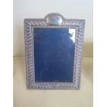 A large silver photo frame with ribbed decoration, approx 26cm high