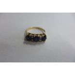 An 18ct gold three stone blue sapphire and diamond rig, size N, approx 2.9 grams, some usage marks