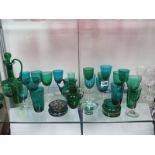 Twenty-seven pieces of green glass ware and seven clear wine glasses, one with a colour twist