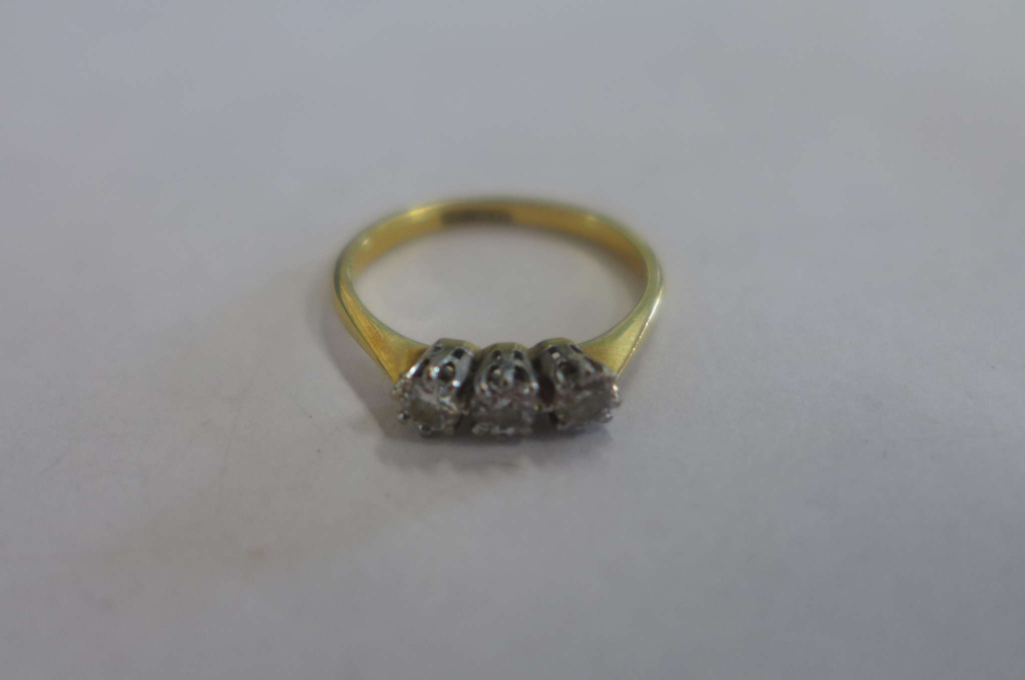 An 18ct gold and platinum three stone diamond ring, size L, approx 2.3 grams