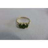 A 9cy yellow gold peridot three stone ring, size N, approx 2 grams, in good condition