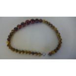 A good graduated set of marbled bakelite amber beads, length 42cm, largest bead diameter 17mm,