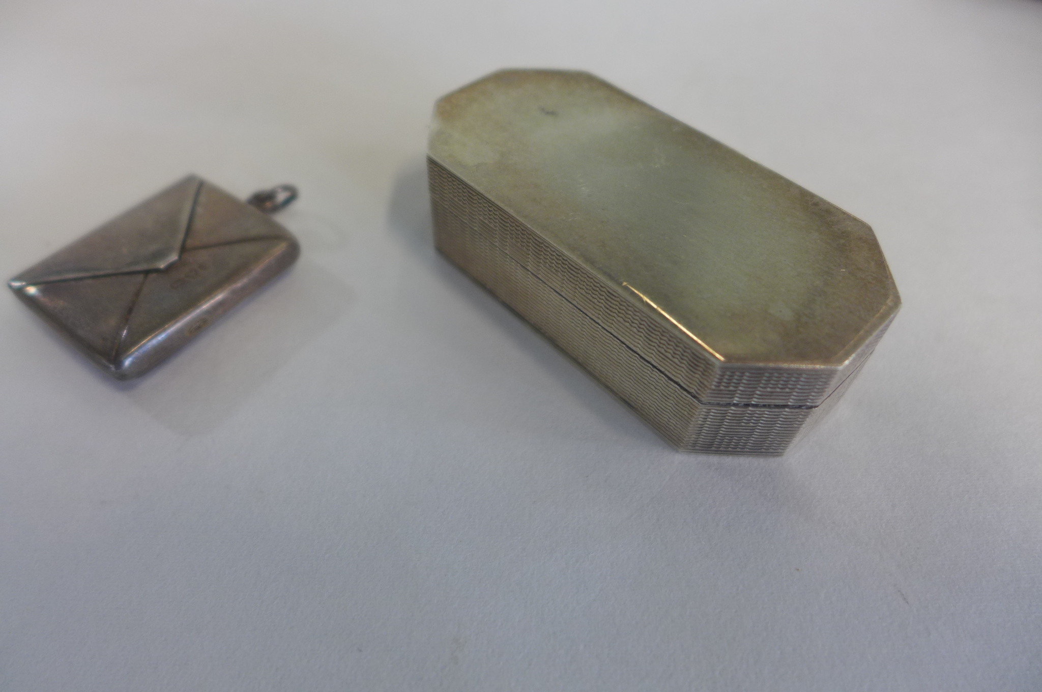 A silver pill box, Birmingham 981, maker PGK, 5.5cm long, and a silver envelope stamp case, 3cm