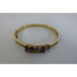A 9ct multi gem set bangle, approx 6cm diameter, approx 13.5 grams, in good condition
