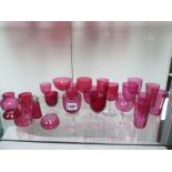 Twenty-four pieces of cranberry glass ware, two pieces damaged otherwise generally good