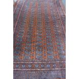 A hand knotted woollen rug with an orange field, 290cm x 190cm