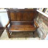 An 18th century and later oak, high back bench, 115cm tall, 111cm wide and 50cm deep