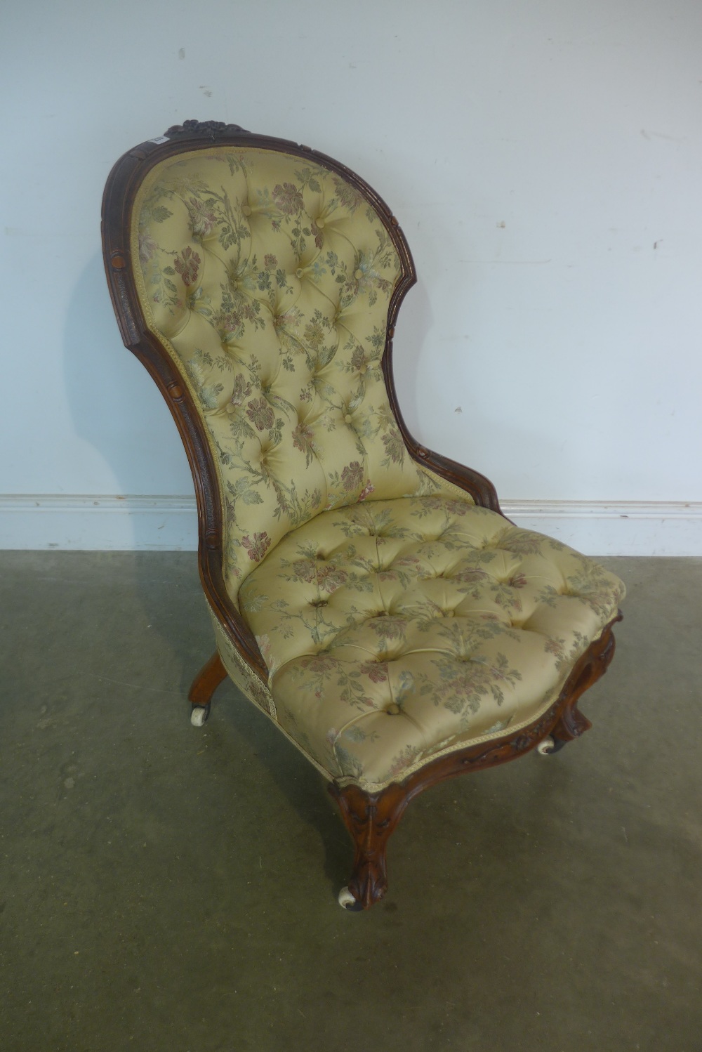 A Victorian walnut button back fireside chair