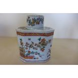 A Chinese 18th century porcelain tea-caddy and cover decorated with Prunus and birds in a red and