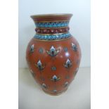 A 19th century Mettlach vase, the terracotta ground decorated with jeweled and flower head repeating