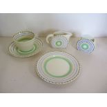 A Clarice Cliff tea cup, saucer, tea plate, sugar bowl and milk jug, with green and yellow rounded