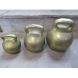 Three 19th Century brass imperial ball weights, with single loop handles, 56lb , 28 lb and 14lb