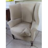 A Georgian style wing back upholstered arm chair, 106cm tall x 81cm wide