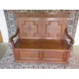An oak hall bench with inlaid panelled back and scroll arms, with lift up seat by Kendal Milne and