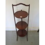 An Edwardian inlaid mahogany three tier folding cake stand