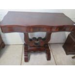 A 19th century continental mahogany side table with a serpentine front which slides to create a