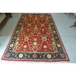 A hand knotted woollen rug with a red field, 300x178cm, generally good condition