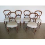 A set of six Victorian walnut balloon back dining chairs, on cabriole legs