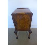 An early 20th century burr walnut bedside cupboard with carved shell and scroll legs and hairy