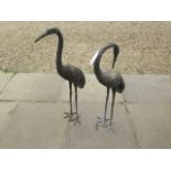 A pair of bronze heron garden figures, 96cm tall