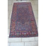 A hand knotted woollen rug, with a blue field and geometric design, 260cm x 140cm - some general