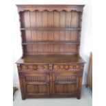 A Brights of Nettlebred oak dresser with open rack top above a two door, two drawer base, 179cm tall