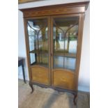 An Edwardian inlaid mahogany two door display cabinet, 81cm tall x 115cm wide x 39cm deep
