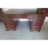 A 20th century mahogany twin pedestal nine drawer desk with a leather inset top, 77cm tall x 153cm x